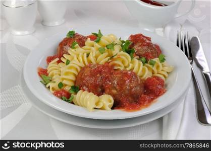 Pasta with meatballs in tomato sauce and herbs