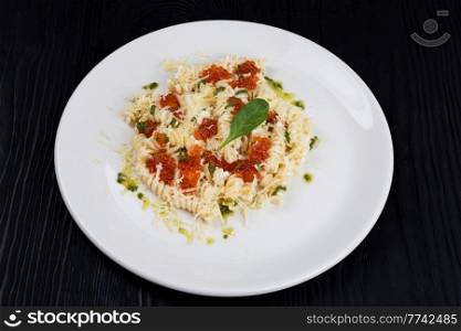 Pasta with red caviar on black wooden background. Pasta with red caviar