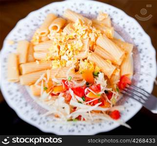 Pasta with salad from tomato and cabbage, selective focus