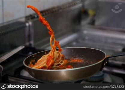 Pasta with sauce frying on pan