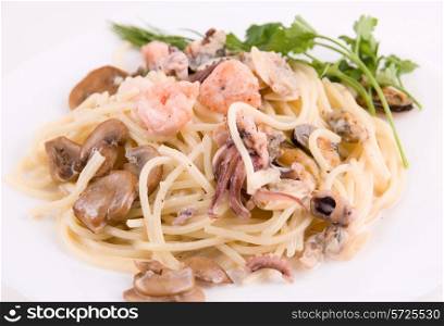 Pasta with seafood and mushrooms on white plate