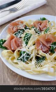 Pasta with spinach, ham and parmesan cheese for milk sauce