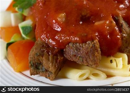 pasta with tomato beef sauce on wooden table