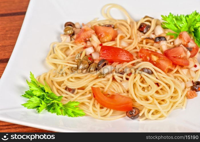 Pasta with tomato, black olives, capers and greens