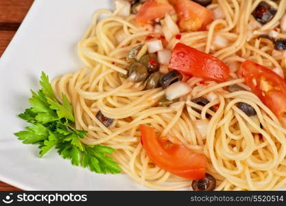 Pasta with tomato, black olives, capers and greens