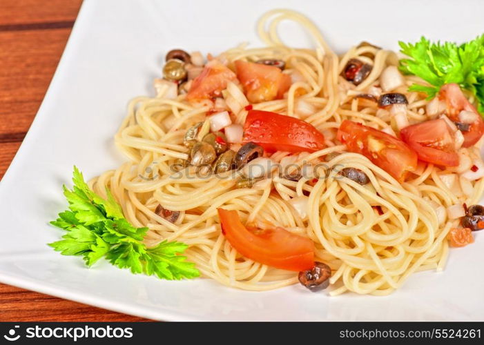 Pasta with tomato, black olives, capers and greens