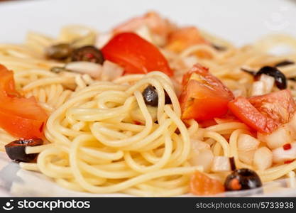 Pasta with tomato, black olives, capers and greens