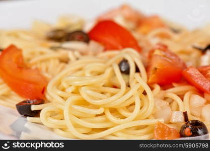 Pasta with tomato, black olives, capers and greens