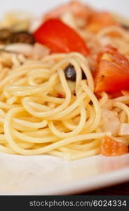 Pasta with tomato, black olives, capers and greens