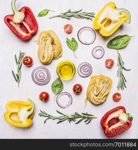 Pasta with vegetables around lie ingredients on wooden rustic background top view close up