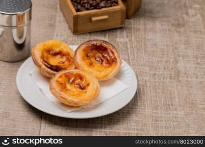 Pasteis de Nata or Portuguese Custard Tarts on wooden table.