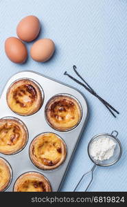 Pasteis de nata, typical Portuguese egg tart pastries from Lisbon on a set table. Top view with copy space