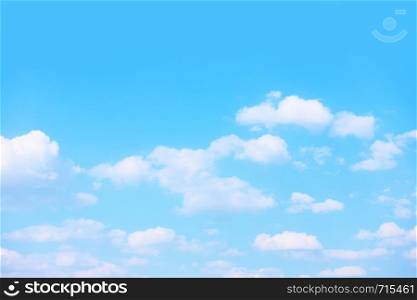 Pastel blue spring sky with white clouds - background
