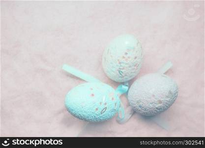 Pastel blurred background - blue decorative Easter eggs on pink sand. Soft focus, space for copy.. Pastel Easter Eggs