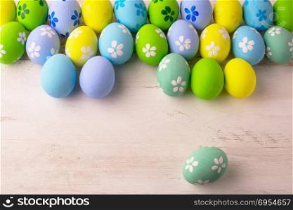 Pastel colored Easter eggs on a white wooden background, copy space