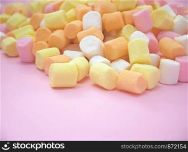 Pastel colored marshmallow on pink background with copyspace.