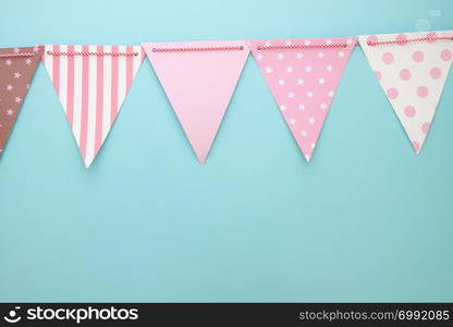 Pastel colour party flags on blue background. Party or anniversary background