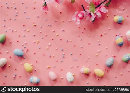 Pastel Easter eggs on pink background top view with natural light. Flat lay style.