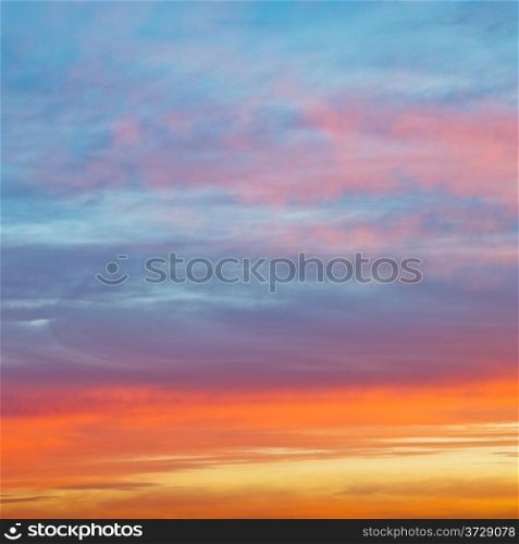 pastel pink and yellow sunrise clouds under blue morning sky in autumn