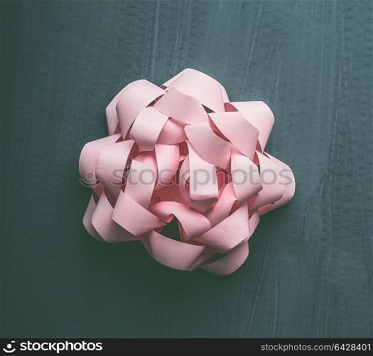 Pastel pink bow on gray background, creative holiday layout, top view