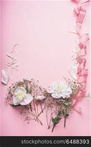 Pastel pink floral background with white flowers and ribbon, top view