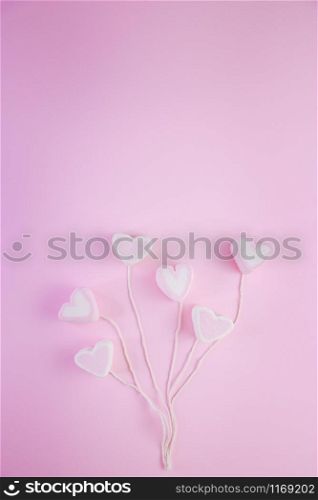 Pastel Valentine background is made of marshmallow souffle in the form of hearts on a string on a pink background. Valentine&rsquo;s day concept with copy space.. Pastel Valentine background is made of marshmallow souffle in the form of hearts on a string on a pink background. Valentine&rsquo;s day concept with copy space