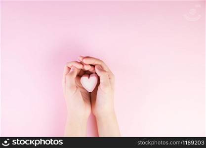 Pastel valentine background made of marshmallows souffle in the form of hearts on a pink background in hands. Valentine&rsquo;s Day concept with copy space.. Pastel valentine background made of marshmallows souffle in the form of hearts on a pink background in hands. Valentine&rsquo;s Day concept with copy space