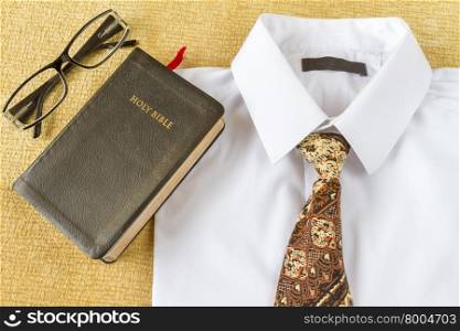 pastos clothes and Holy Bible and glasses at home