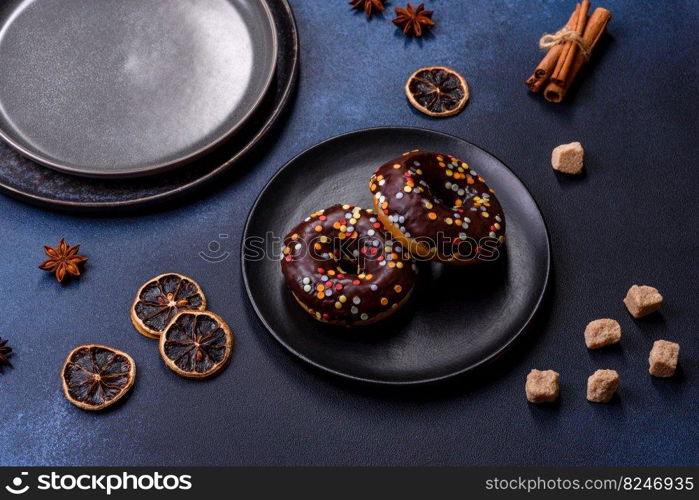 Pastries concept. Donuts with chocolate glaze with sprink≤s, on a dark concrete tab≤. Sweet food for a breakfast. Pastries concept. Donuts with chocolate glaze with sprink≤s, on a dark concrete tab≤