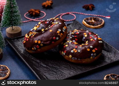 Pastries concept. Donuts with chocolate glaze with sprinkles, on a dark concrete table. Sweet food for a breakfast. Pastries concept. Donuts with chocolate glaze with sprinkles, on a dark concrete table