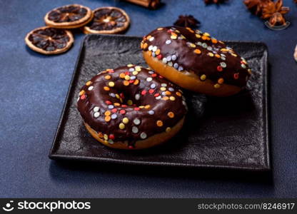 Pastries concept. Donuts with chocolate glaze with sprinkles, on a dark concrete table. Sweet food for a breakfast. Pastries concept. Donuts with chocolate glaze with sprinkles, on a dark concrete table