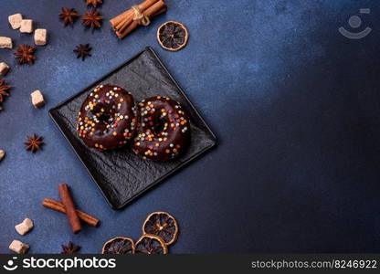 Pastries concept. Donuts with chocolate glaze with sprinkles, on a dark concrete table. Sweet food for a breakfast. Pastries concept. Donuts with chocolate glaze with sprinkles, on a dark concrete table