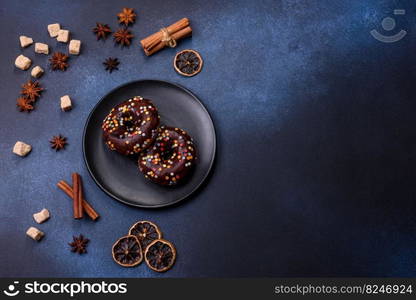 Pastries concept. Donuts with chocolate glaze with sprinkles, on a dark concrete table. Sweet food for a breakfast. Pastries concept. Donuts with chocolate glaze with sprinkles, on a dark concrete table