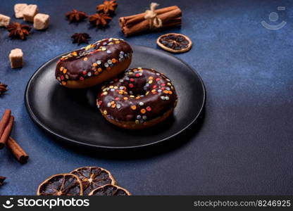 Pastries concept. Donuts with chocolate glaze with sprinkles, on a dark concrete table. Sweet food for a breakfast. Pastries concept. Donuts with chocolate glaze with sprinkles, on a dark concrete table