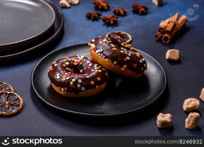 Pastries concept. Donuts with chocolate glaze with sprinkles, on a dark concrete table. Sweet food for a breakfast. Pastries concept. Donuts with chocolate glaze with sprinkles, on a dark concrete table