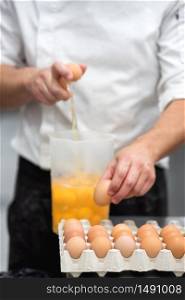 Pastry Chef breaking eggs to prepare the cake .. Pastry Chef breaking eggs to prepare the cake