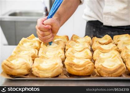 Pastry chef decorates biscuit tartlet with cream from pastry bag close-up. High quality photo. Pastry chef decorates biscuit tartlet with cream from pastry bag close-up