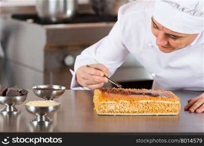 Pastry chef decorating cake yolk and cream