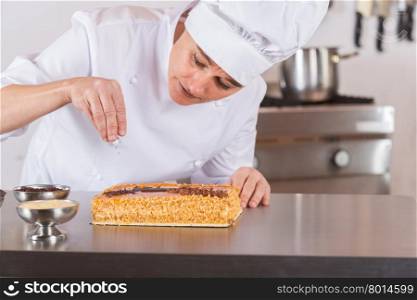 Pastry chef decorating cake yolk and cream