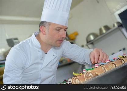 pastry chef finishing off christmas logs