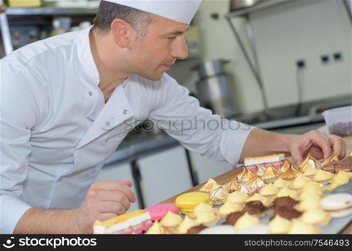 pastry chef holding delicious looking cakes and pastries