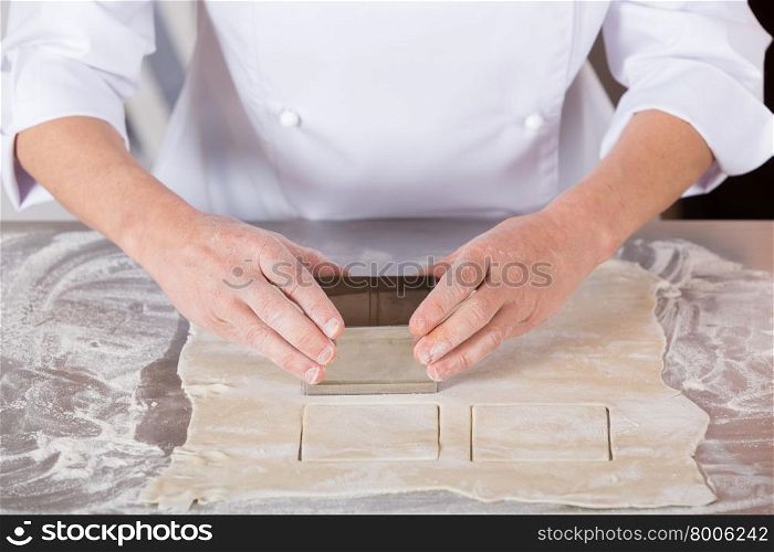 Pastry kneading a dough of a cake