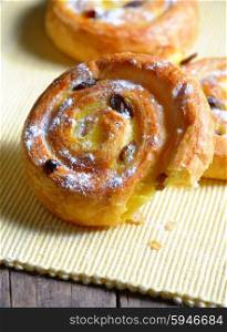 Pastry swirls with raisins on old wood