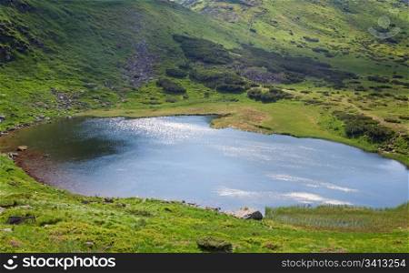 Patch of sunlight on Alpine lake Nesamovyte surface (Ukraine, summer mountain Chornogora Ridge, Carpathian Mountains)