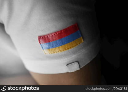 Patch of the national flag of the Armenia on a white t-shirt.. Patch of the national flag of the Armenia on a white t-shirt