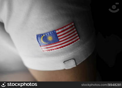 Patch of the national flag of the Malaysia on a white t-shirt.. Patch of the national flag of the Malaysia on a white t-shirt