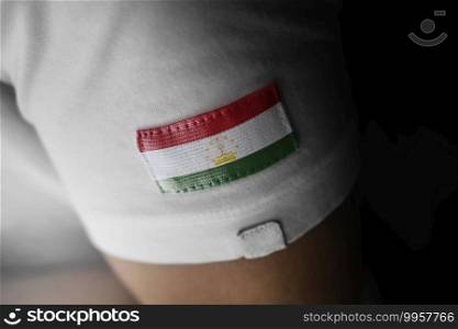 Patch of the national flag of the Tajikistan on a white t-shirt.. Patch of the national flag of the Tajikistan on a white t-shirt