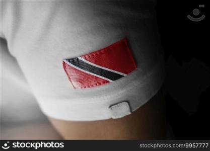 Patch of the national flag of the Trinidad and Tobago on a white t-shirt.. Patch of the national flag of the Trinidad and Tobago on a white t-shirt