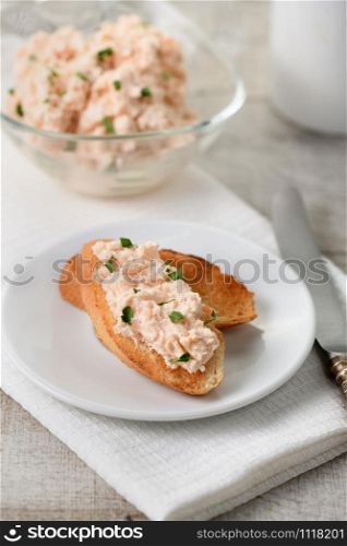 pate salmon with soft cheese and herb, toasted sliced bread, vintage knife with a textile napkin on a wooden table
