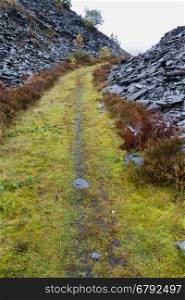 Path between slate tips. Wales, United Kingdom